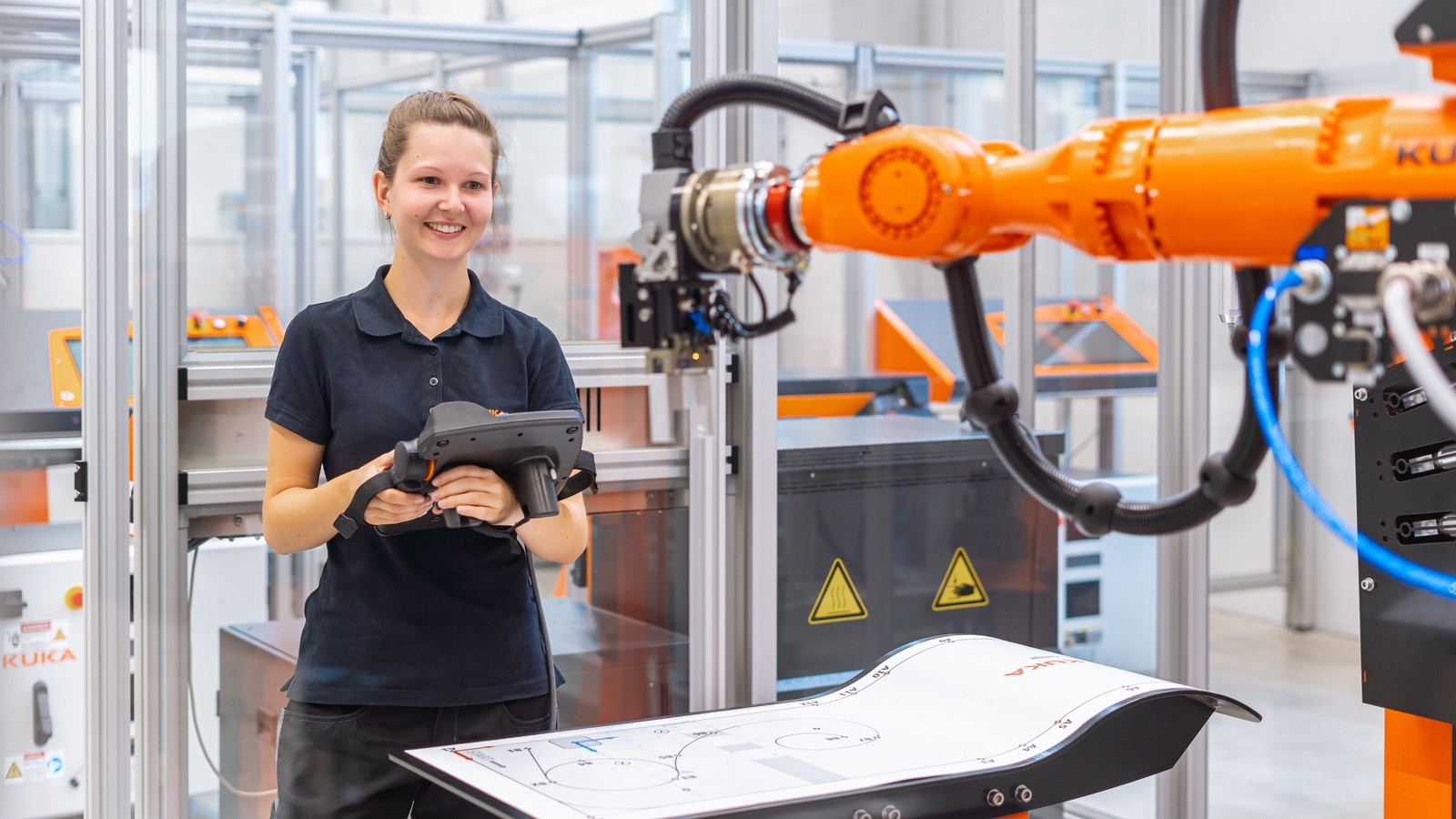Engineer working beside an industrial robotic arm