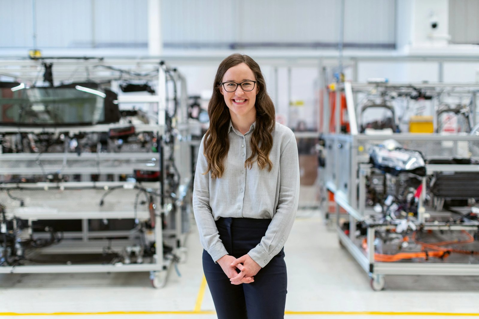 Engineer standing beside a robotic production system in a professional laboratory